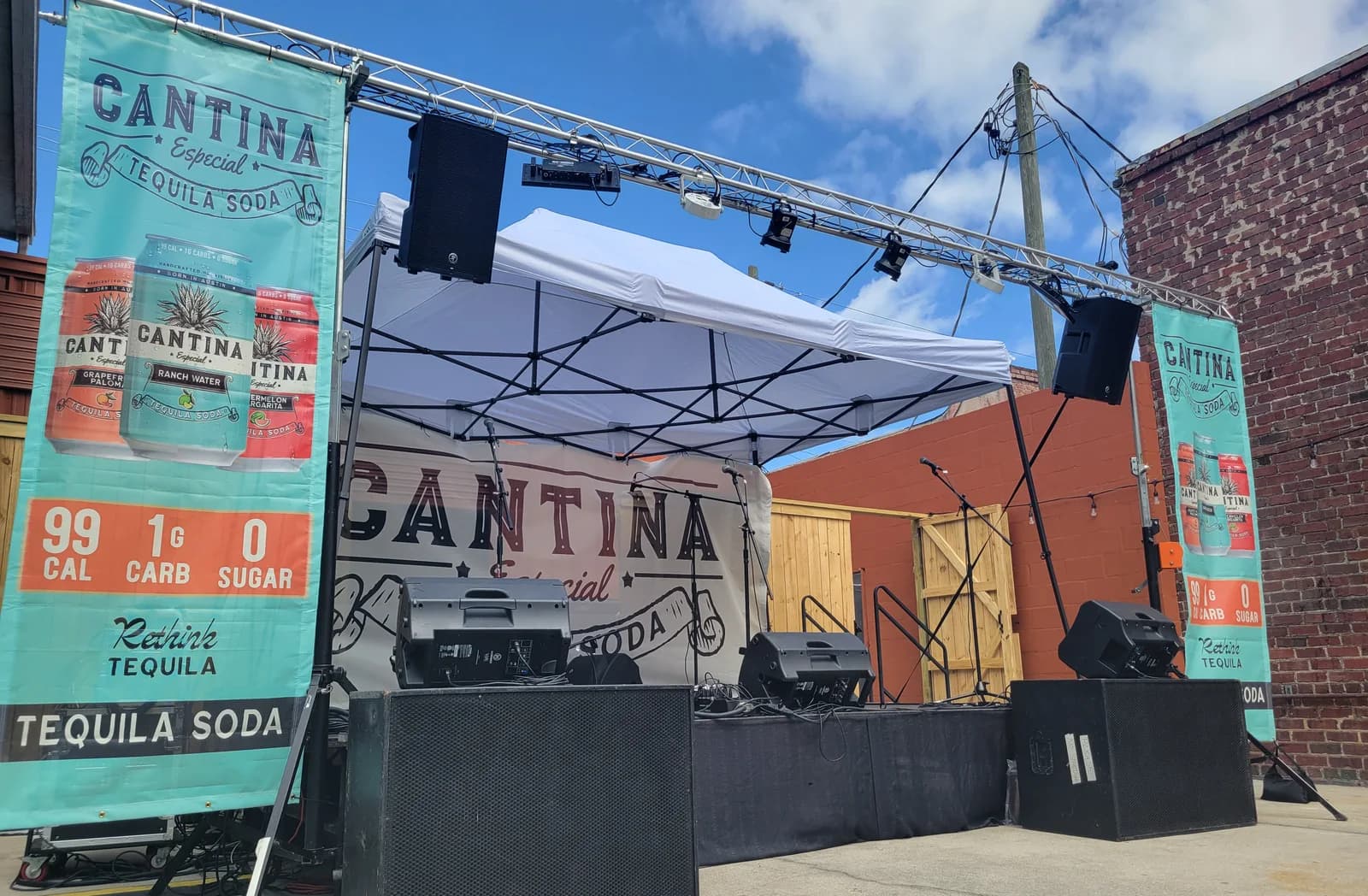 The same 12x16 stage built outdoors, with sponsor banners hung in the left, right and back positions the plan marks out