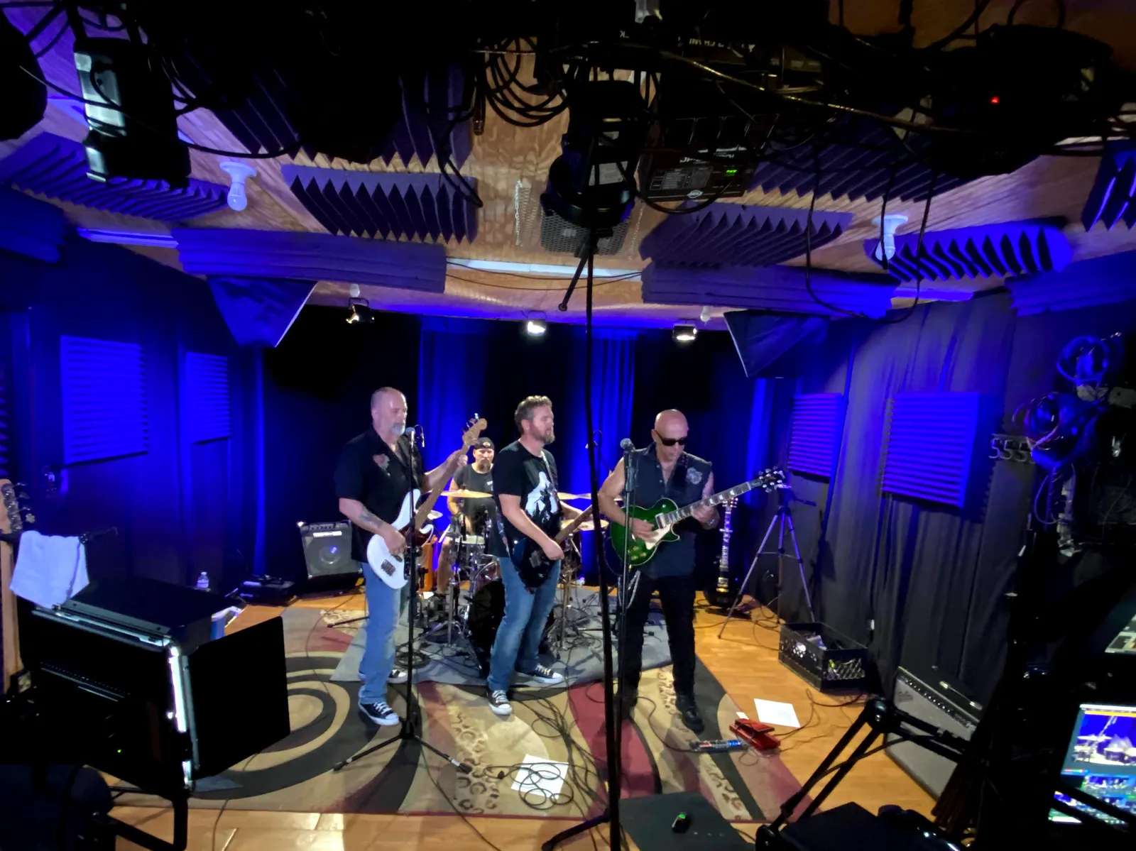 A band rehearsing under blue light in the CFAV rehearsal studio, with acoustic foam overhead